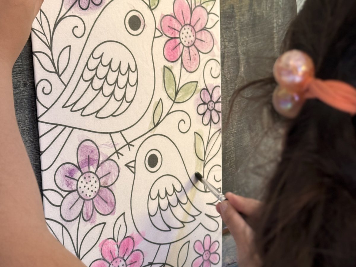 Manos de un niño coloreando un dibujo durante el taller de arte