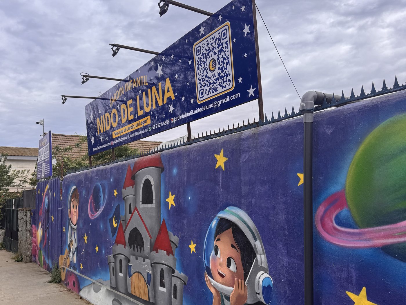 Muro lateral del jardín pintado con planetas y estrellas