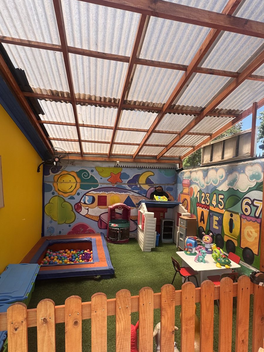 Patio techado del jardín, con cerco de madera y juegos
