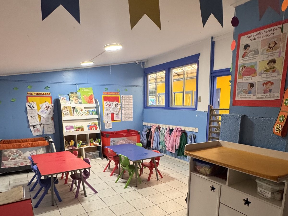 Sala decorada con banderines de colores y mesas de trabajo